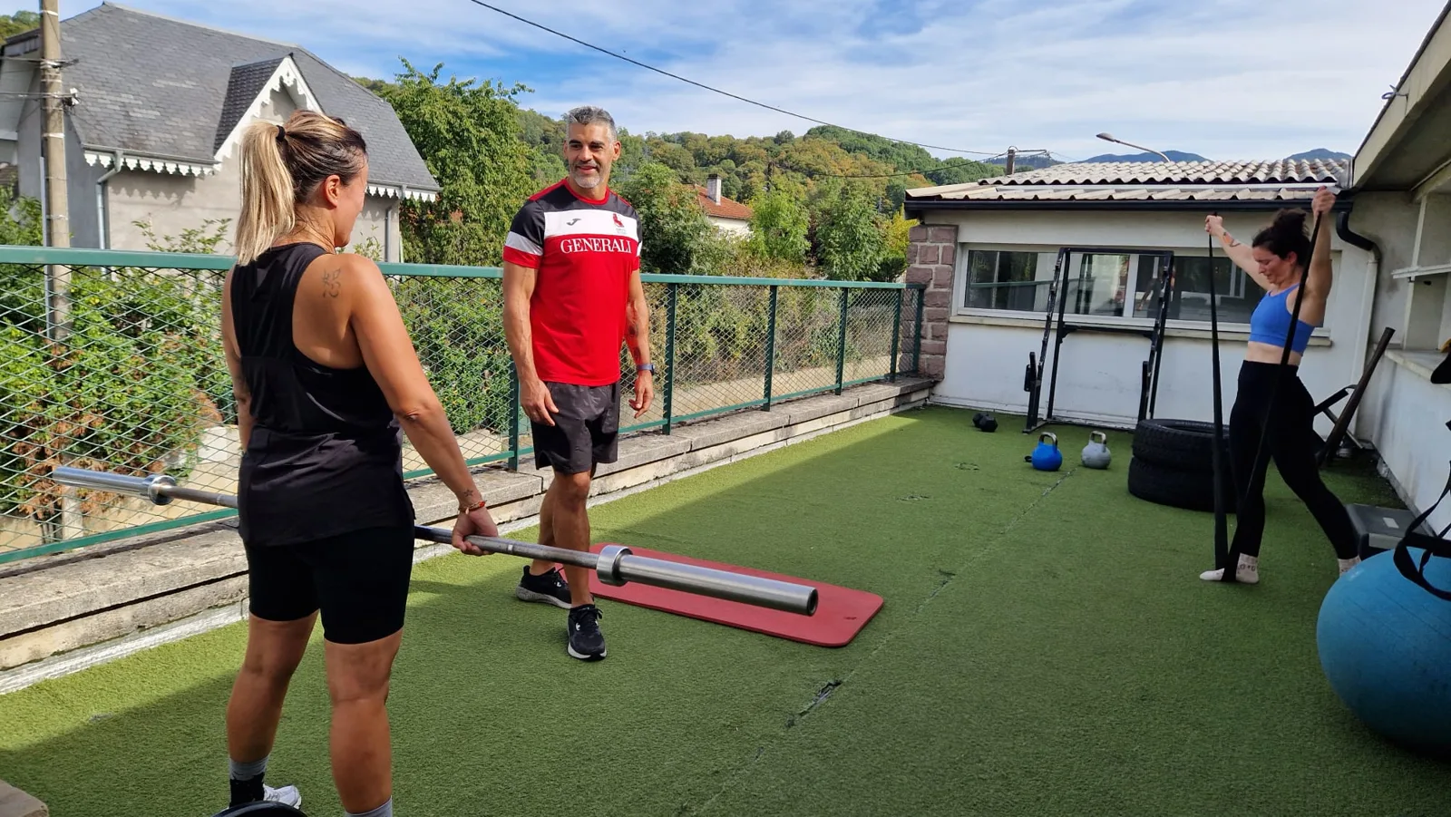 Le coach suit l'exécution d'une adhérente sur la terrasse.