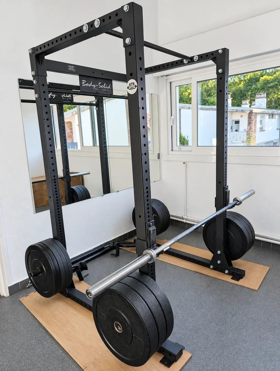 Rack de force avec barre olympique et disques.