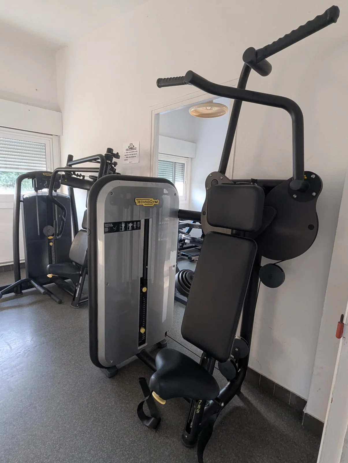 Machines guidées Technogym : traction verticale et développé.